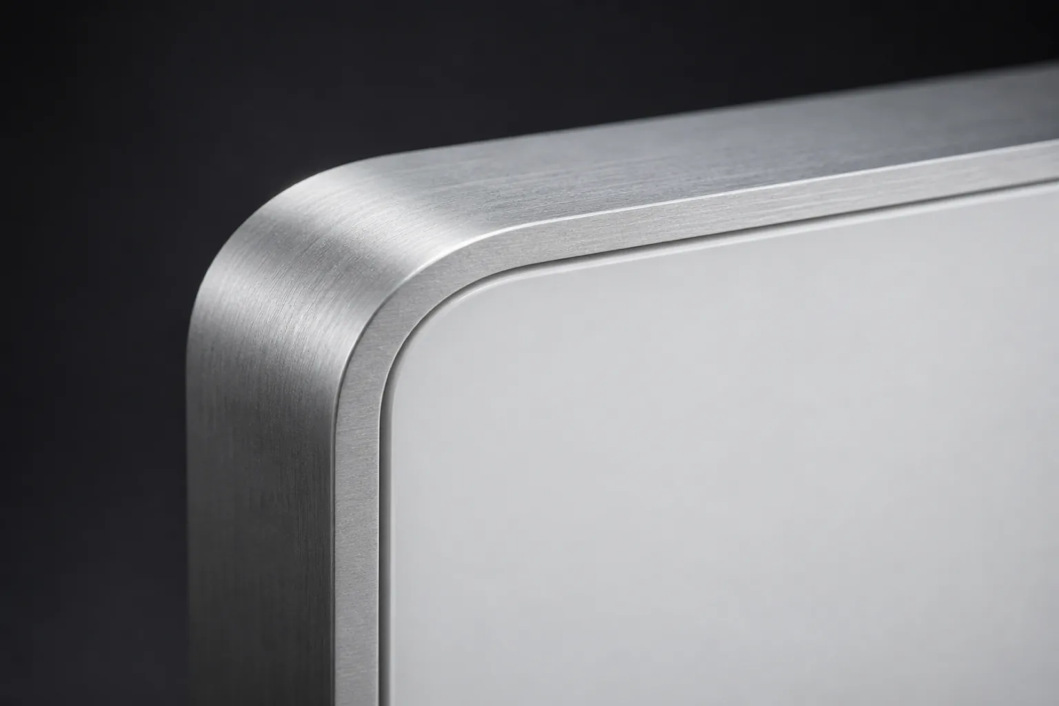 Macro photograph of a brushed aluminum corner framing a matte white acrylic panel